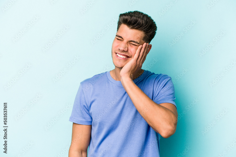 Young caucasian man isolated on blue background covering ears with hands. Young caucasian man isolated on blue background covering ears with hands.
