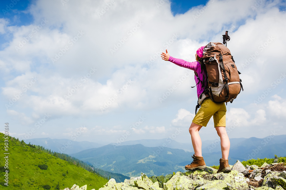 Happy hiker with her arms outstretched, freedom and happiness in the mountains