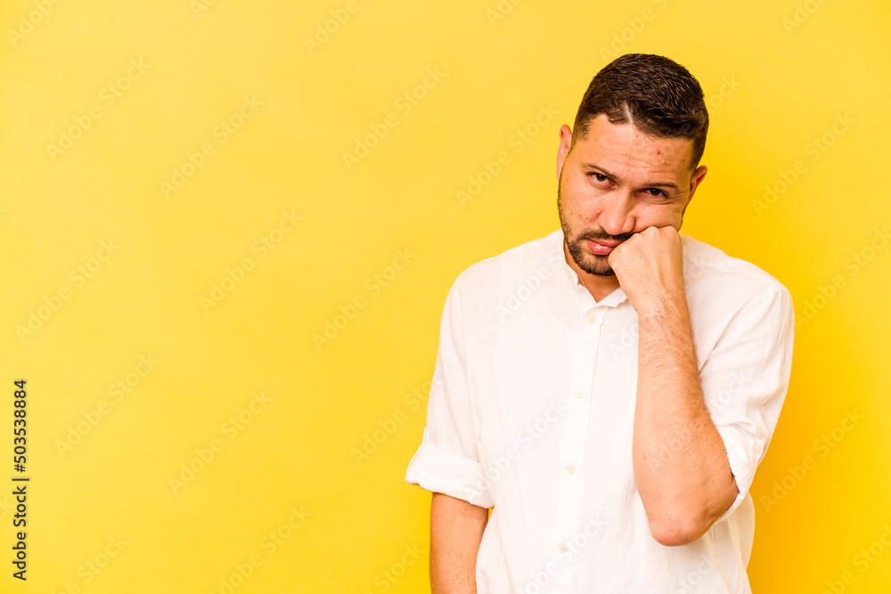 Young hispanic man isolated on yellow background who feels sad and pensive, looking at copy space. Young hispanic man isolated on yellow background who feels sad and pensive, looking at copy space.