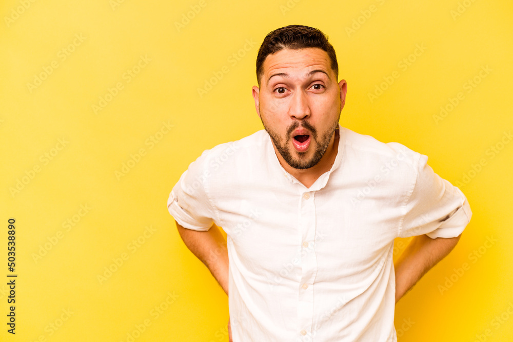 Young hispanic man isolated on yellow background being shocked because of something she has seen. Young hispanic man isolated on yellow background being shocked because of something she has seen.