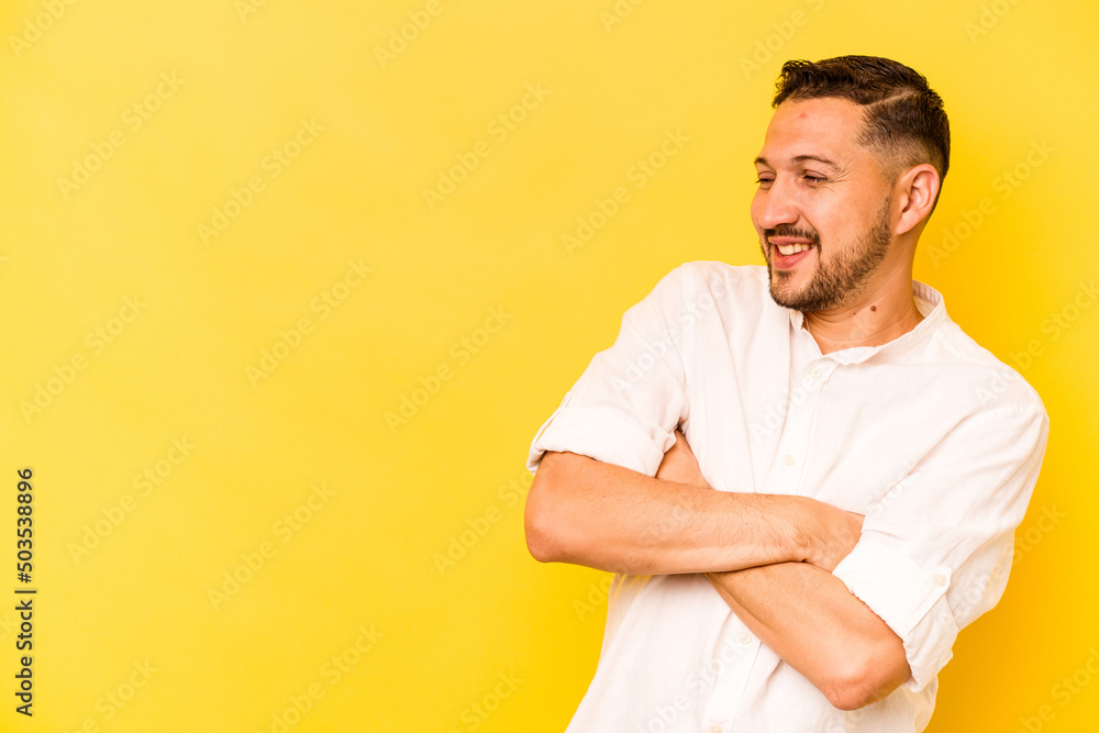 Young hispanic man isolated on yellow background smiling confident with crossed arms. Young hispanic man isolated on yellow background smiling confident with crossed arms.