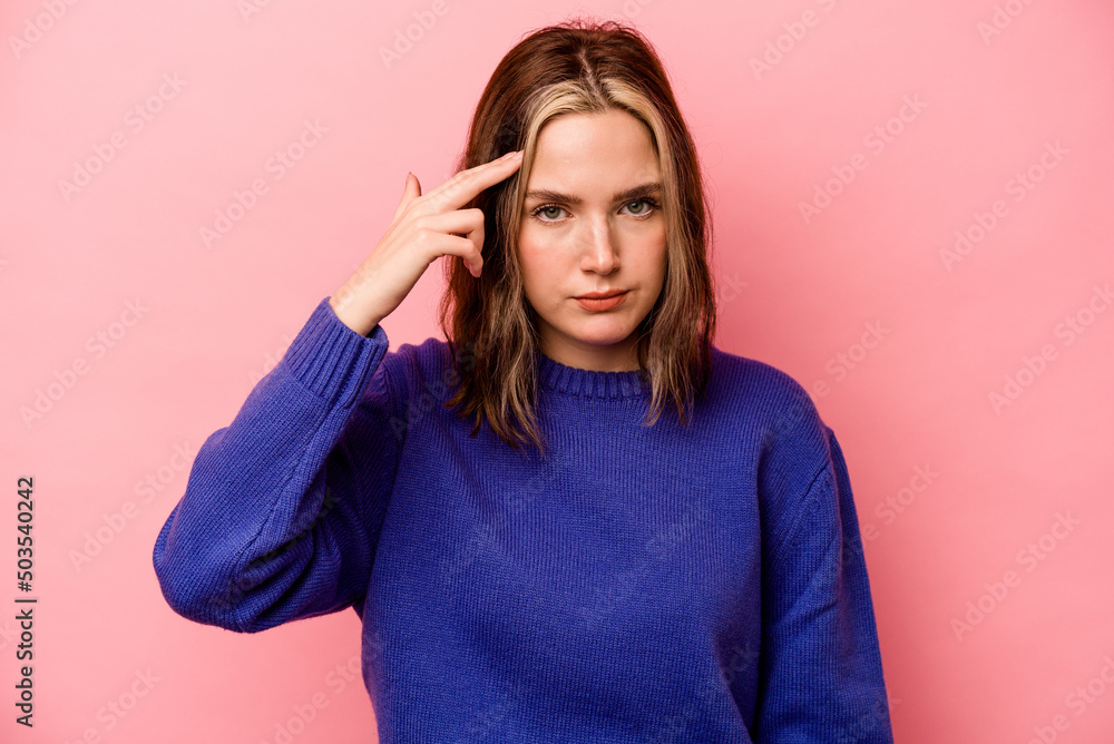 Young caucasian woman isolated on pink background pointing temple with finger, thinking, focused on a task. Young caucasian woman isolated on pink background pointing temple with finger, thinking, focused on a task.