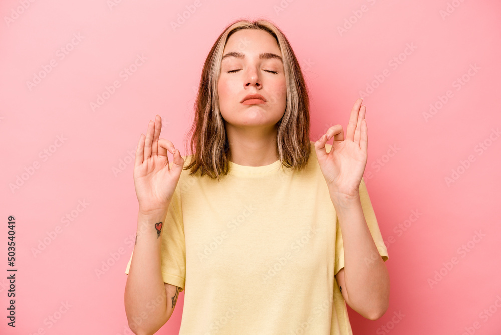 Young caucasian woman isolated on pink background relaxes after hard working day, she is performing yoga. Young caucasian woman isolated on pink background relaxes after hard working day, she is performing yoga.
