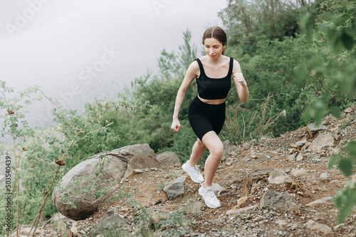 Exercising outdoors is healthy for active lifestyle runners. Autumn trail run woman running in nature near lake. Outdoor jog.