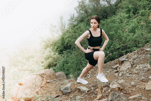 Young female runner stretching arms and legs before running at morning forest trail near lake © ALEXSTUDIO
