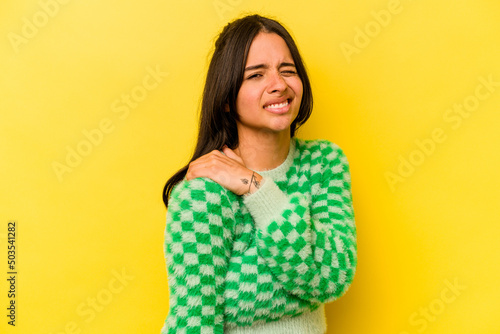 Young hispanic woman isolated on yellow background having a shoulder pain.