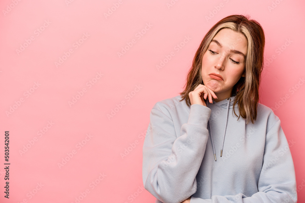 Young caucasian woman isolated on pink background looking sideways with doubtful and skeptical expression. Young caucasian woman isolated on pink background looking sideways with doubtful and skeptical expression.