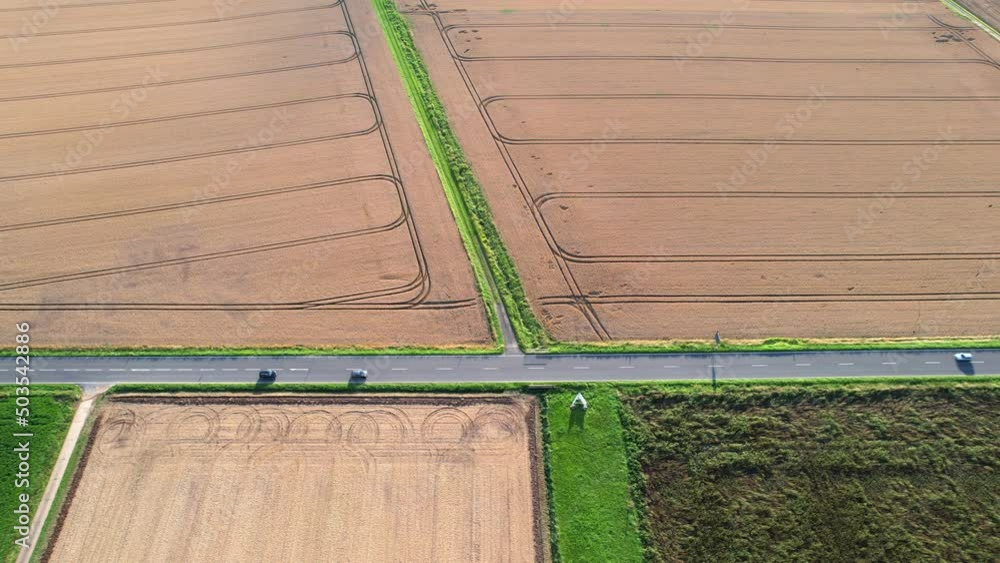 Top view drone shot of cars driving on a country road through agricultural landscape, transportation concept. Top view drone shot of cars driving on a country road through agricultural landscape, transportation concept.