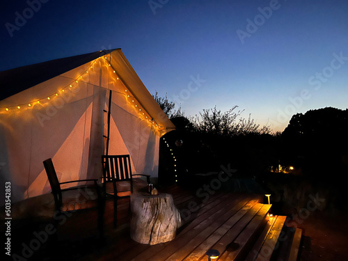Glamping tent with lights at sunset 
