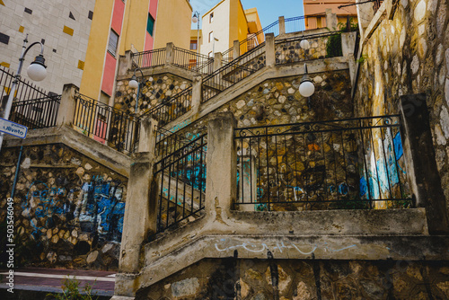 Fototapeta Naklejka Na Ścianę i Meble -  Low angle beautiful staircase buildings with graffiti in Messina in Sicilia, Italy
