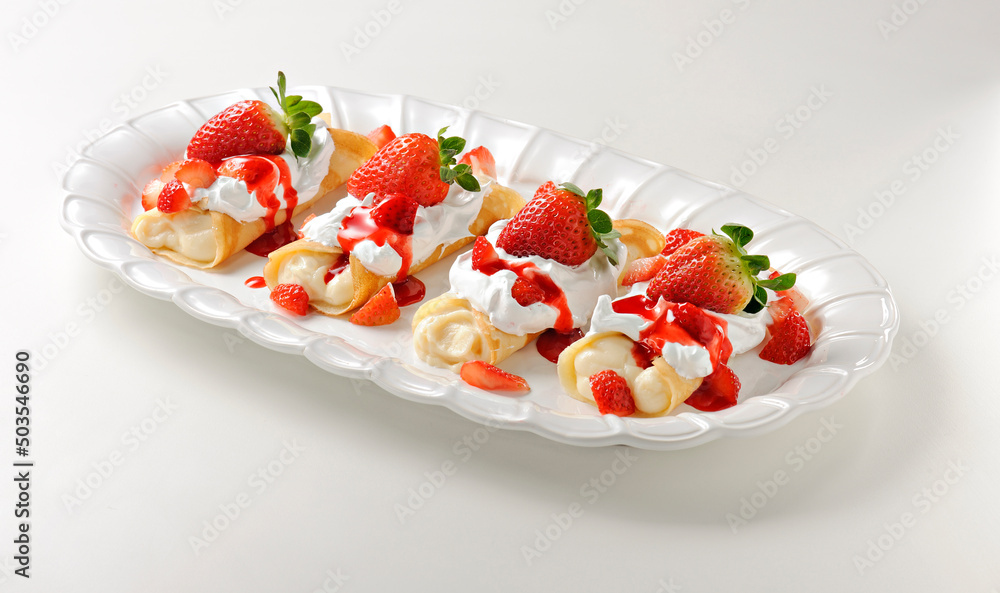 Set of four delicious crepes with strawberry and cream filling, and chantilly topping, isolated
