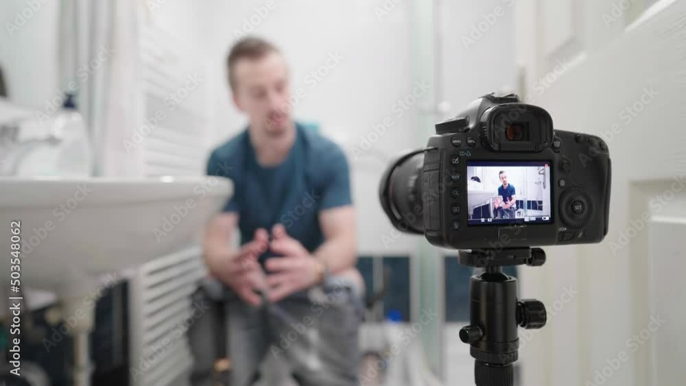 Male influencer in bathroom on toilet recording video with DSLR camera selling shit 4K Male influencer in bathroom on toilet recording video with DSLR camera selling shit 4K