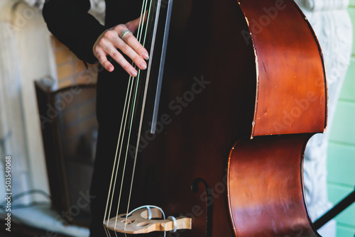 Photography Concert view of contrabass violoncello player with vocalist and musical band dur