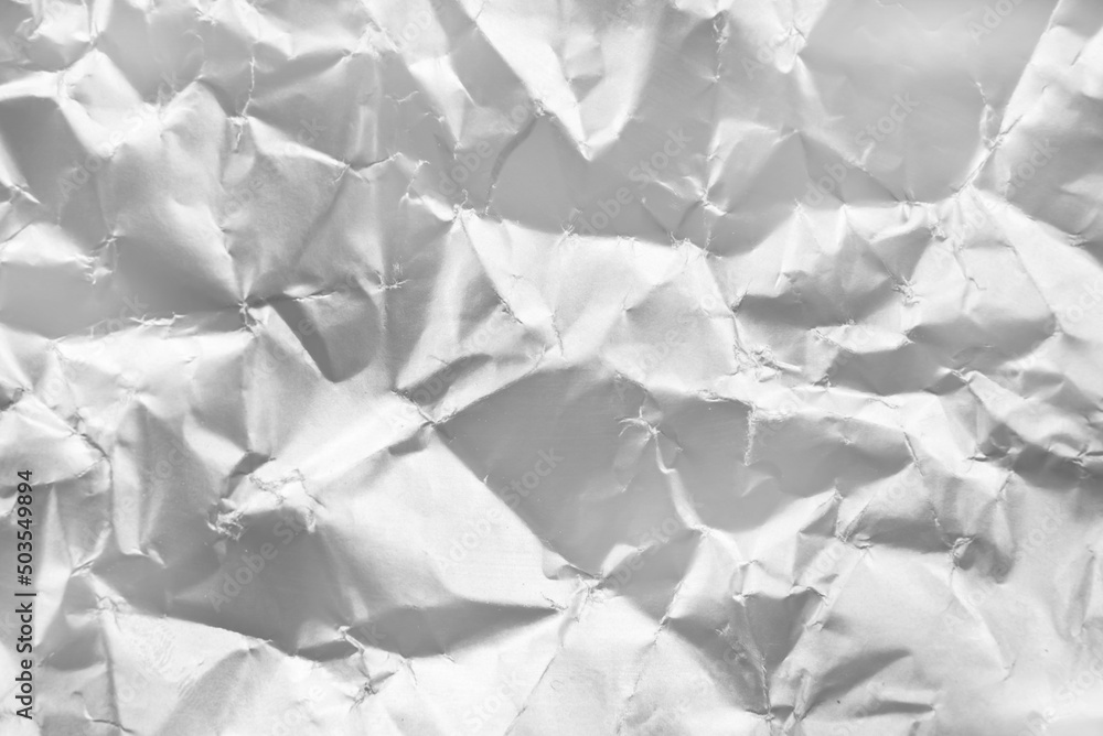 Background from crumpled paper in silver color. Paper with scuffs and waves Background from crumpled paper in silver color. Paper with scuffs and waves