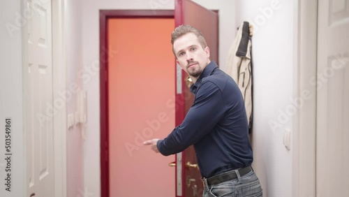 Attractive man open door and show way out with strict gesture 4K photo