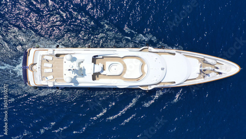 Aerial drone top down photo of luxury yacht with wooden deck cruising in deep blue sea of Mykonos island, Cyclades, Greece © aerial-drone