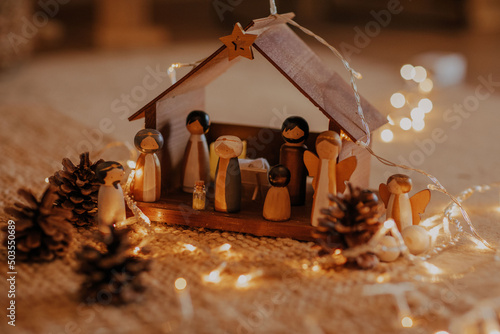 Selective focus shot of a nativity scene surrounded by Christmas lights photo