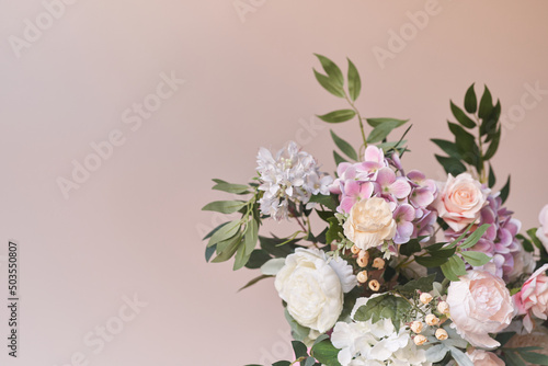 A gorgeous pastel pink bouquet of peonies in close-up on a sand-colored background. Flowers in interior design. Cozy house. High quality photo
