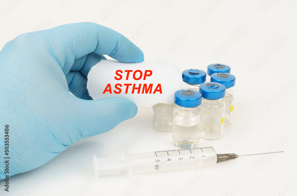 In his hand is a piece of paper with the inscription - STOP ASTHMA, next to it lies a syringe and injection jars. In his hand is a piece of paper with the inscription - STOP ASTHMA, next to it lies a syringe and injection jars.