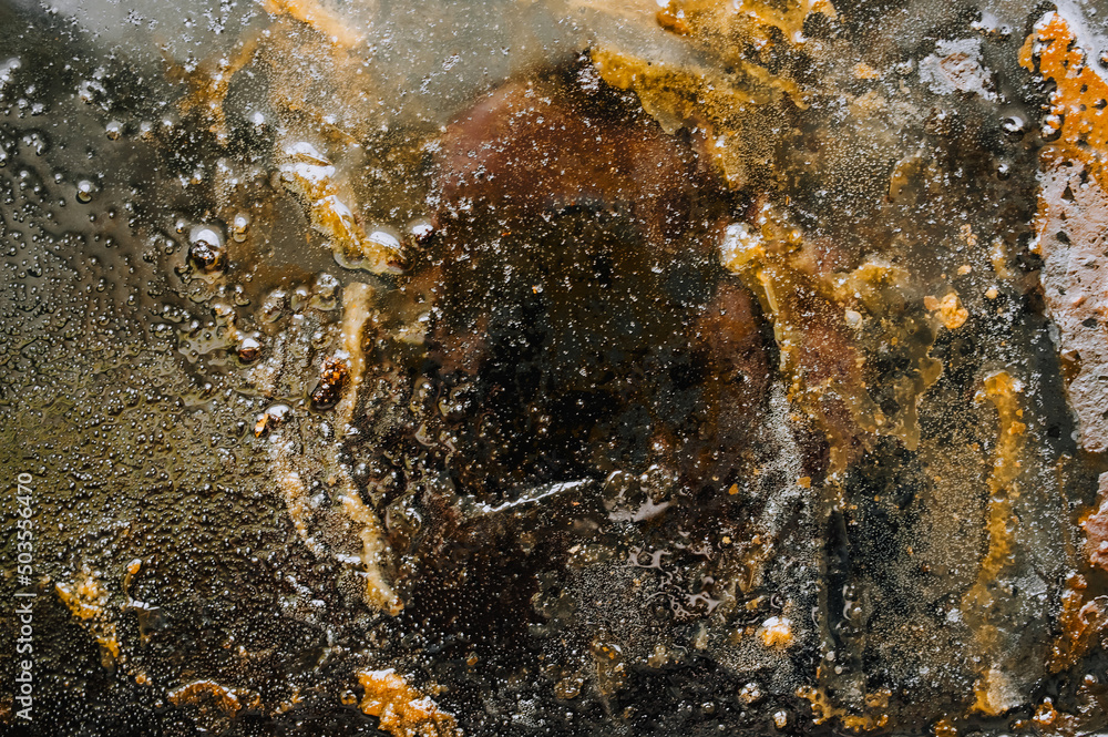 Texture, background, top view of a black tray smeared in fat, after cooking a meat dish. Food photography, abstract. Texture, background, top view of a black tray smeared in fat, after cooking a meat dish. Food photography, abstract.