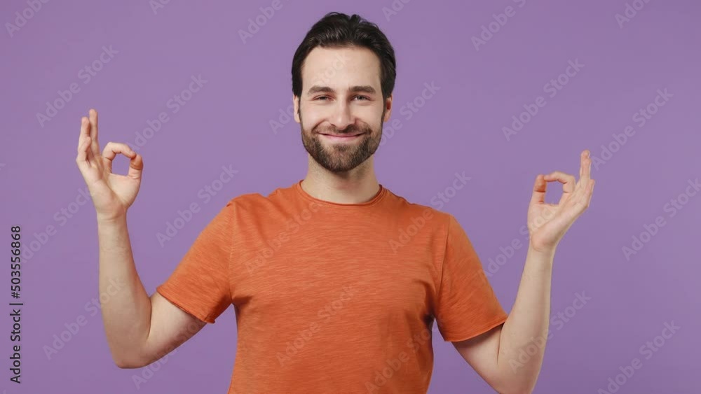 Spiritual tranquil young brunet bearded man 20s wears red t-shirt hold spreading hands in yoga om aum gesture meditate try to calm down isolated on plain pastel light purple background studio portrait Spiritual tranquil young brunet bearded man 20s wears red t-shirt hold spreading hands in yoga om aum gesture meditate try to calm down isolated on plain pastel light purple background studio portrait