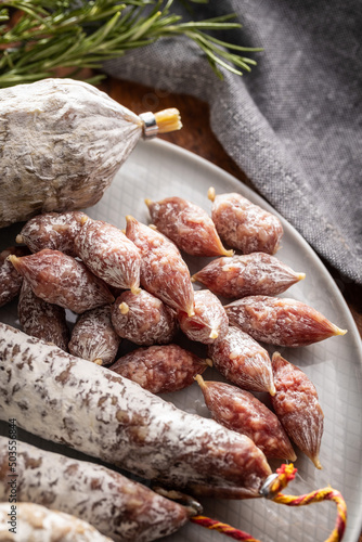 Traditional sausage with white mold. Dried pork salami on plate.