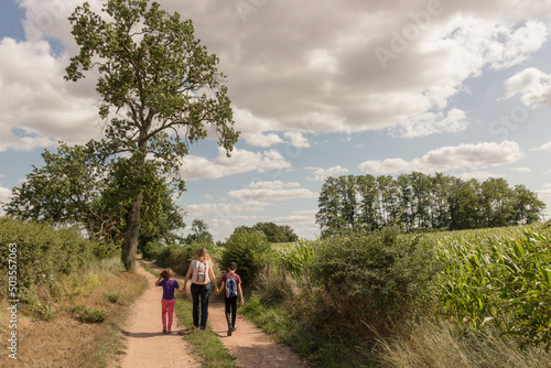 maman et ses deux enfants en train de se promener à la campagne photo