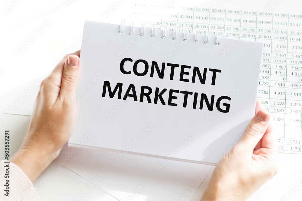 Content Marketing word in notebook in the hands of a girl at a table, a business concept Content Marketing word in notebook in the hands of a girl at a table, a business concept