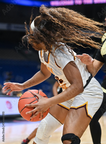 Fotografía Girl with long hair dribbling the ball in a basketball game