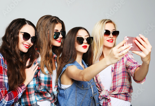 happy teenage girls with smartphone taking selfie