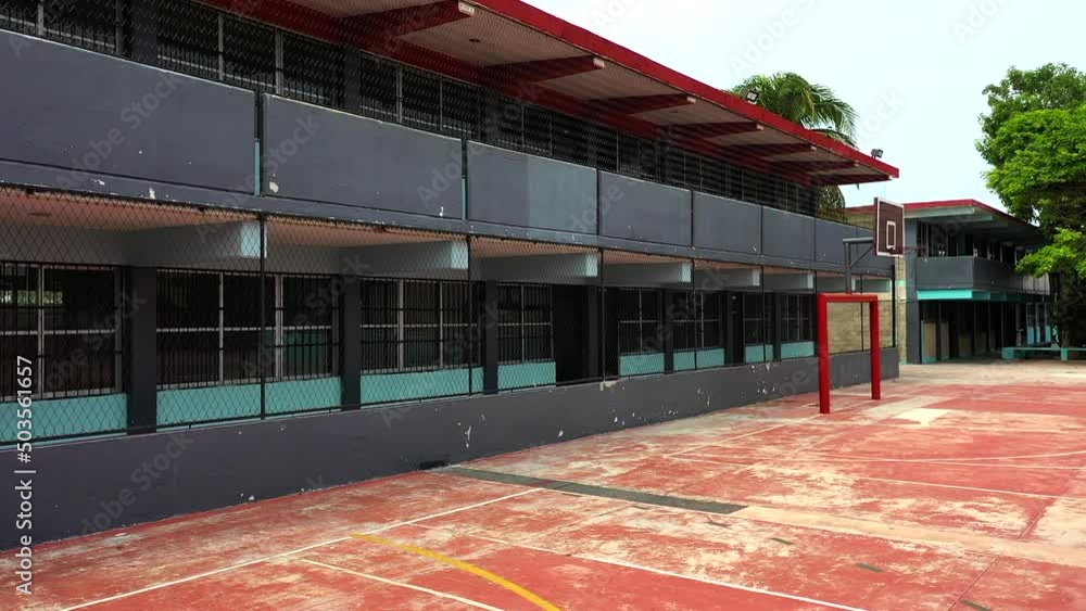 An unmarked, unlabeled school building in Latin America, with bars on ...