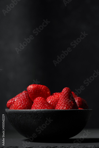 Bol elegante de fresas frescas jugosas y ecológicas en su punto de maduración