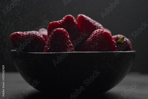 Bol elegante de fresas frescas jugosas y ecológicas en su punto de maduración