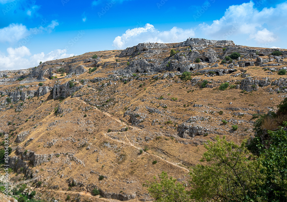 Landscape of the hills of Matera where we can recognize the oldest cave houses inhabited by man. Beautiful summer day.