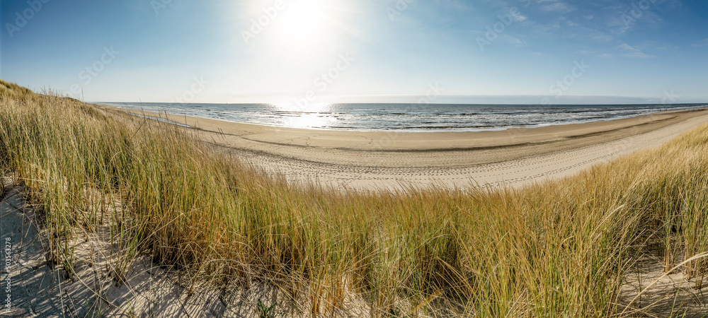 Panoramic landscape background banner panorama of sand dune, beach and ocean North Sea with blue sky, clouds and sunbeams Panoramic landscape background banner panorama of sand dune, beach and ocean North Sea with blue sky, clouds and sunbeams