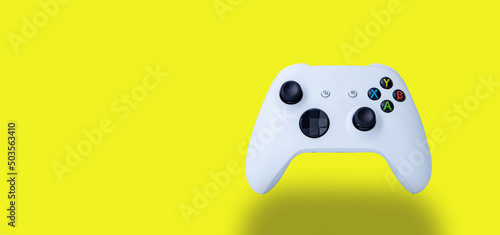 White controller of the new video game console. On yellow background