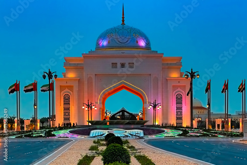 Corniche Road in Abu Dhabi during the blue hour with the illuminated entrance gate to the presidential palace 