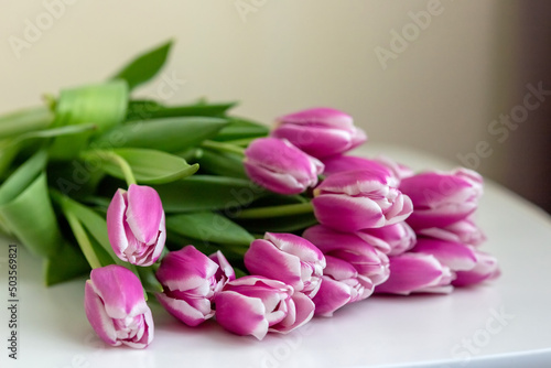A big bouquet of beautiful pink tulips lies on a white background .