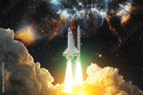 Spaceship flight. Space shuttle with smoke and blast takes off into the starry sky and clouds of gas or dust in space. Rocket starts into nebula. Concept. Elements of this image furnished by NASA. © hamara