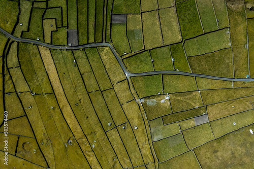 Green grass fields between stone fences of walls. Aerial top down view on meadow. Irish landscape. Aran Island, county Galway, Ireland. Popular and famous travel area. photo