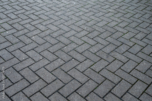 Surface of a stone pavement in a square. Gray color. Selective focus.