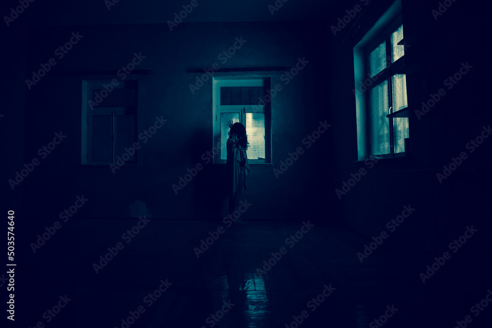 Fototapeta premium Horror woman in window wood hand hold cage scary scene halloween concept Blurred silhouette of witch. Horror theme