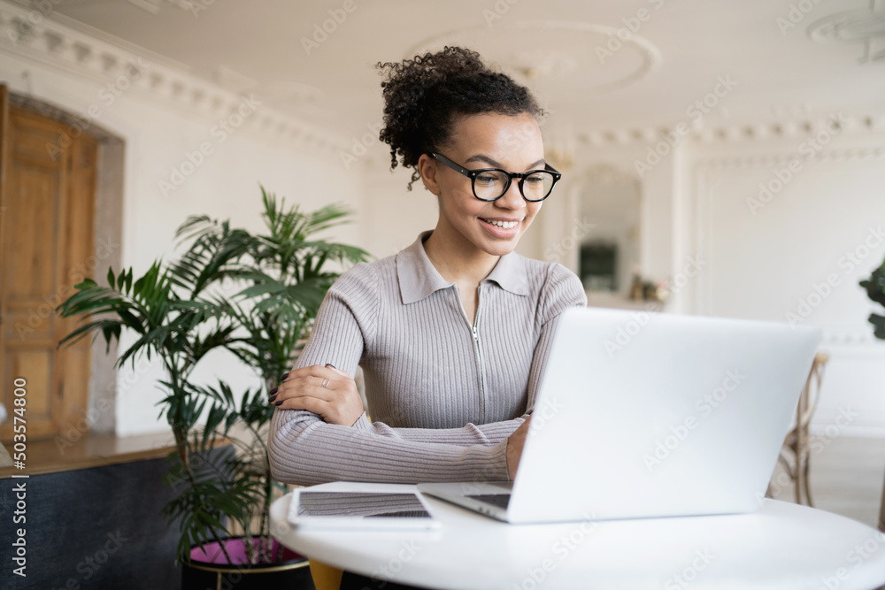 The administrator is a woman working in a modern office using a laptop computer communicating online video communication with colleagues. The administrator is a woman working in a modern office using a laptop computer communicating online video communication with colleagues.
