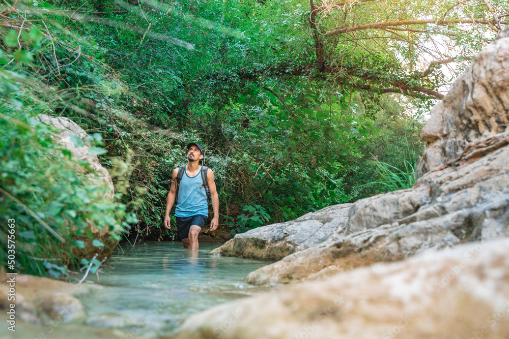Young happy man walking in turquoise blue crystal clear water in the river summer vacation relaxing body and mind. Young happy man walking in turquoise blue crystal clear water in the river summer vacation relaxing body and mind.