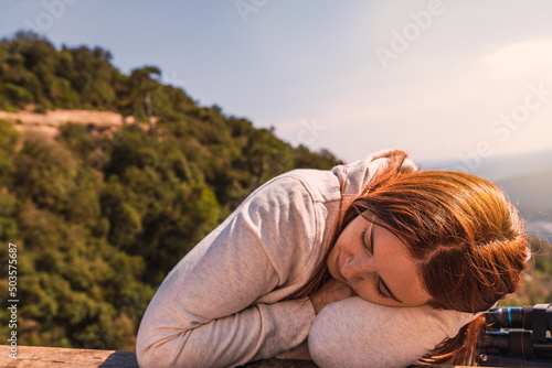 young woman sleeping on the summit of a mountain after finishing the route. young woman on a trip. woman hiker resting. © A&NStudio