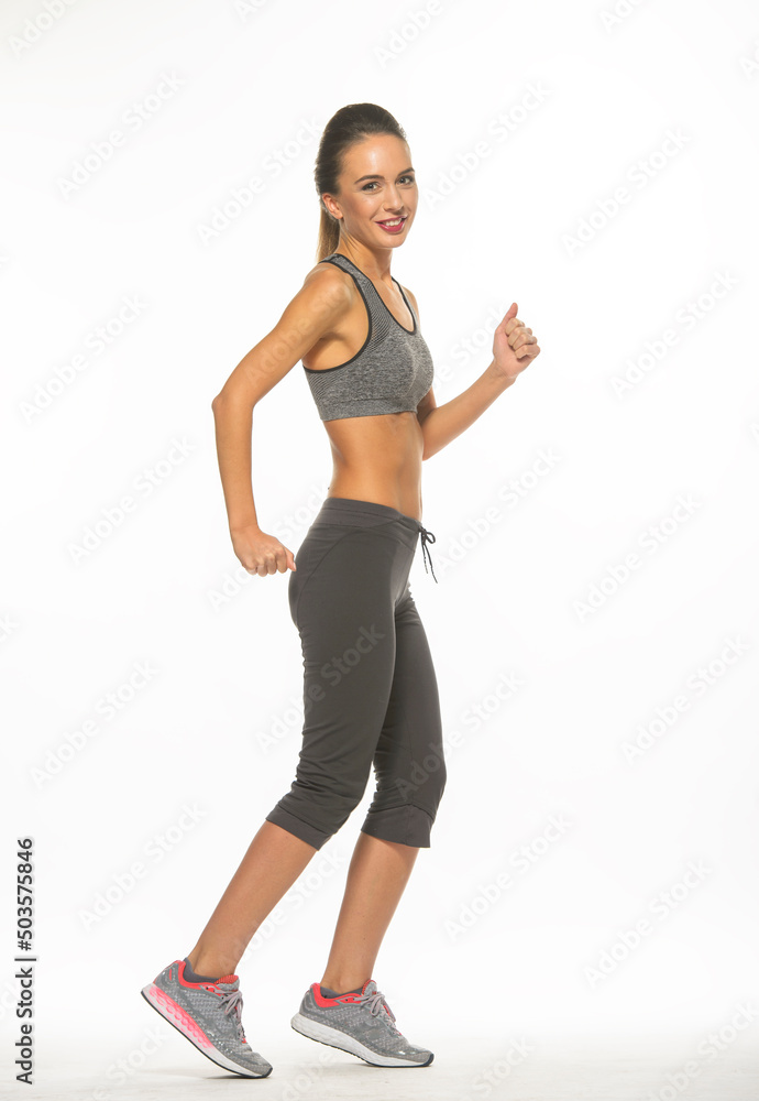 athletic girl in training clothes posing on a white background in the studio in full growth
