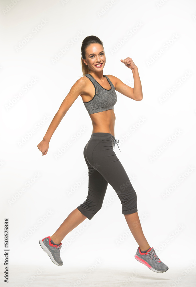 athletic girl in training clothes posing on a white background in the studio in full growth

