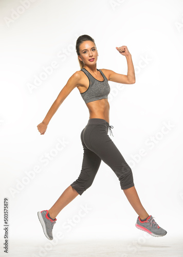 athletic girl in training clothes posing on a white background in the studio in full growth  © serhii
