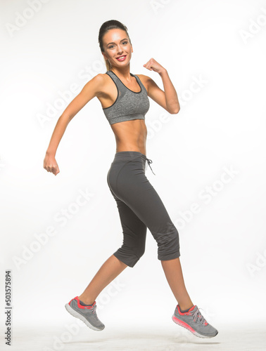 athletic girl in training clothes posing on a white background in the studio in full growth 