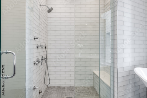Modern Luxury Bathroom. All white bathroom with glass tile. Contemporary bath and shower design. Glass enclosed shower.